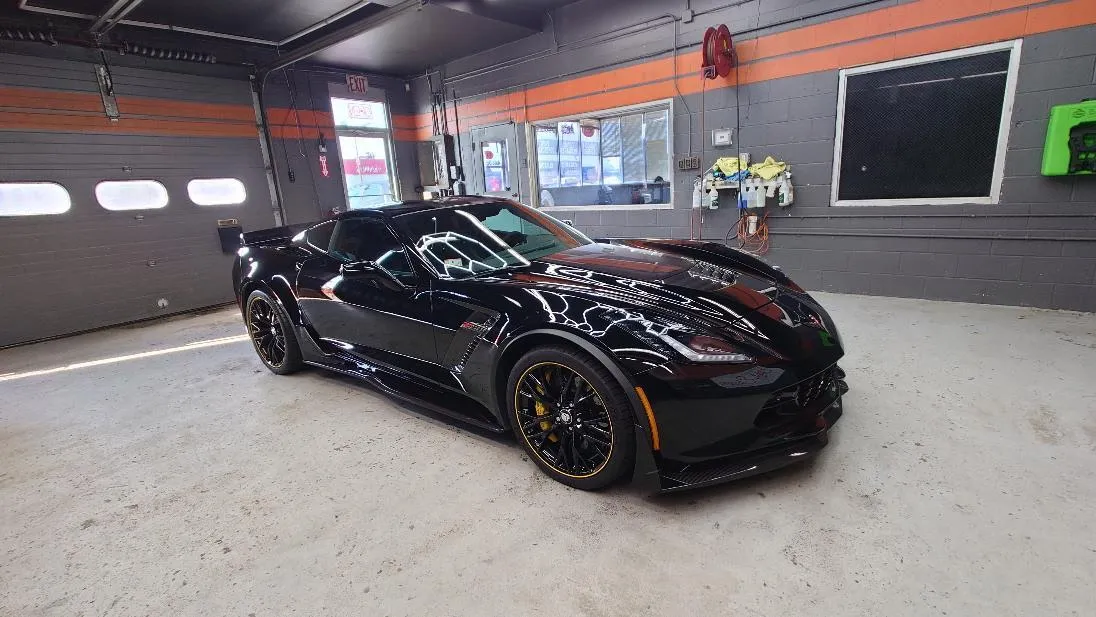 A black Chevrolet Corvette with a full aero package, photographed in our bay in West Springfield, MA after a detail.