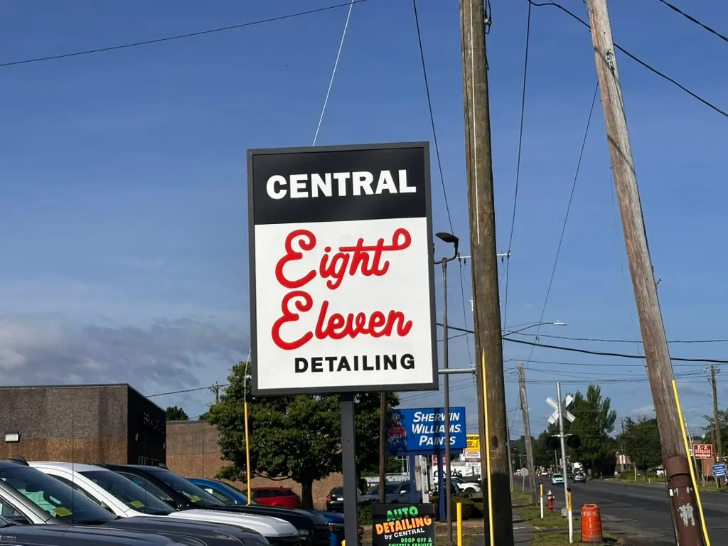 Our street sign on Memorial Avenue in West Springfield — the black-and-cream topper and red script the whole brand is built around.
